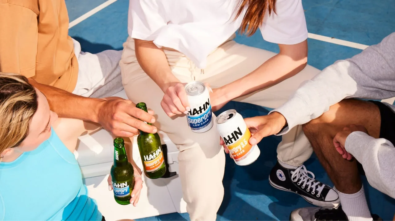 Friends enjoying a variety of Hahn beers on a blue sports court